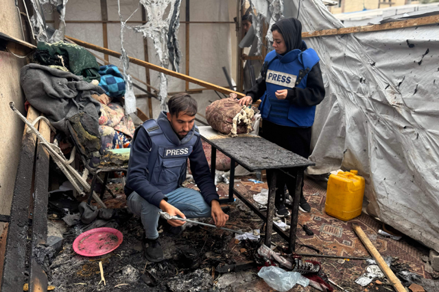 Palestinian journalists inspect the debris and damage after an Israeli strike hit a tent used by journalists in the southern city of Khan Yunis on April 7, 2025 (AFP photo)