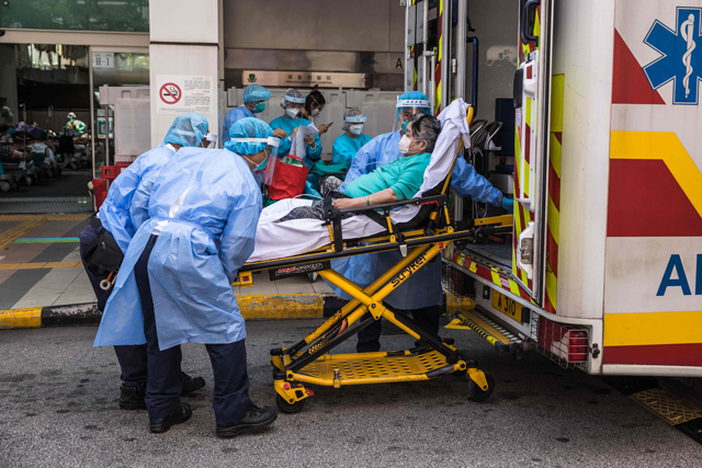 Health workers wearing personal protective equipment (PPE) move a patient from an ambulance outside the accident and emergency department of Princess Margaret hospital in Hong Kong on Friday (AFP photo)