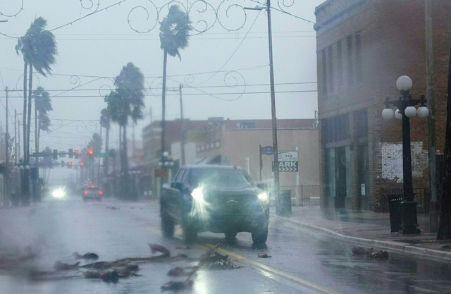 A pickup truck drives around fallen debris and palm trees in the Ybor City neighbourhood ahead of Hurricane Ian making landfall on Wednesday in Tampa, Florida (AFP photo)