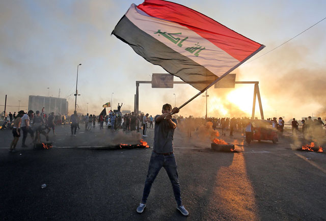 An Iraqi protester waves the national flag during a demonstration against state corruption, failing public services and unemployment, in the Iraqi capital Baghdad, on Saturday (AFP  photo)