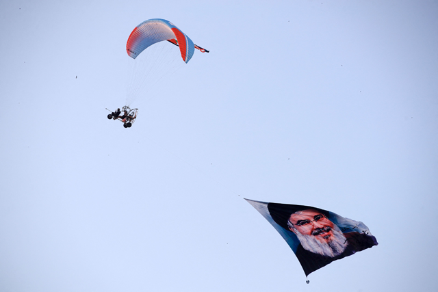 A paraglider flies a large picture of slain Hizbollah leader Hassan Nasrallah over Tahrir Square in central Baghdad, during a protest against the ongoing Israeli bombardment of the Gaza Strip and Lebanon, on October 11, 2024 (AFP photo)
