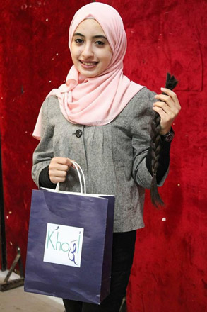 A volunteer holds natural hair donated to make wigs for cancer patients in Amman on Monday  (Photo courtesy of Khusal initiative)