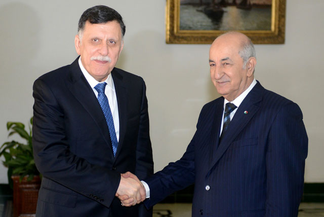 This handout photo released by the official Algeria Press Service  on Monday shows Algeria's President Abdelaziz Tebboune (right) shaking hands with Libya's UN-recognised Prime Minister Fayez Al Sarraj after their meeting in Algiers on Monday for talks on the Libyan crisis (AFP photo)