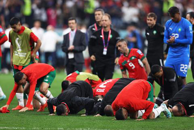 Morocco's players pray and thank the crowd after losing 2-0 in the Qatar 2022 World Cup semifinal football match between France and Morocco at Al Bayt Stadium in Al Khor, north of Doha, on Wednesday (AFP photo)