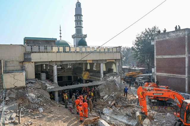 Security personnel and rescue workers search for victims amid the debris of a damaged mosque a day after a blast inside the police headquarters in Peshawar on Tuesday (AFP photo)