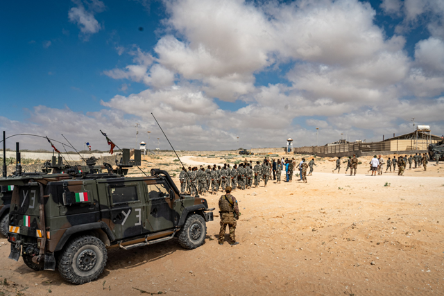 An European Union Training Mission in Somalia (EUTM-S) soldier watches over a morning briefing held for Somali Army Cadet Officers Course (SOCAC) troops at the General Dhagabadan Training Centre in Mogadishu on March 19 (AFP photo)