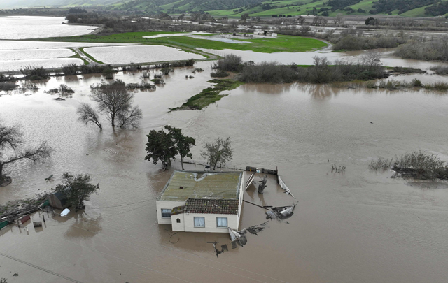 In an aerial view, a home is seen submerged in floodwater as the Salinas River begins to overflow its banks on Friday in Salinas, California (AFP photo)