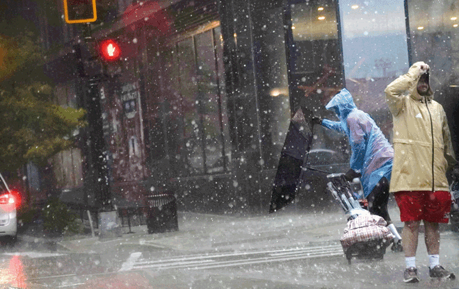 An umbrella is blown inside out as a person crosses the street during a storm in Washington, DC, on Monday (AFP photo)