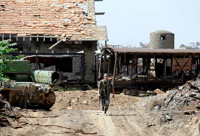 This photo taken on Sunday during a government guided tour in Damascus’ southern Al Qadam neighbourhood shows a Syrian army soldier walking near the damaged train station (AFP photo)
