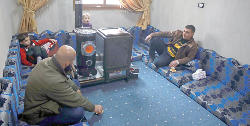 Abu Walid warms his living room with a pistachio-powered heater in Tal Al Karama village in Syria's northwestern province of Idlib on December 6 (AFP photo)