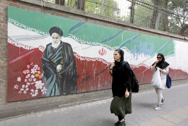 An Iranian woman walks past a mural on the wall of the former US embassy in the Iranian capital Tehran on May 8 (AFP photo)