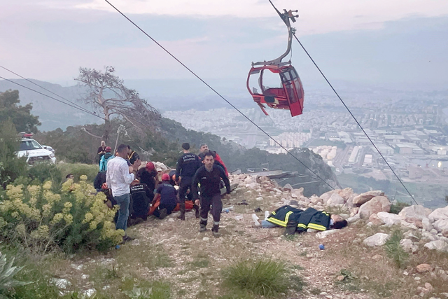 This handout photograph taken and released on Friday by Turkish news agency DHA (Demiroren News Agency) shows rescue teams conducting a rescue operation and helping injured people after a cable car cabin crashed into a fallen cable pole in Konyaalti district of Antalya (AFP photo)
