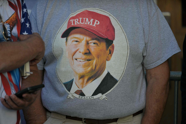 A man wears a t-shirt with a picture of former US president Ronald Reagan wearing a Trump hat as supporters line up for a rally with Republican presidential nominee, former US President Donald Trump at Santander Arena in Reading, Pennsylvania, on October 9, 2024 (AFP photo)