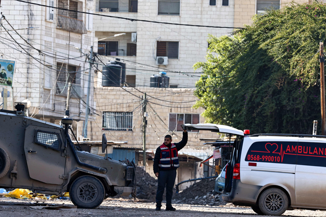 A Palestinian paramedic opens the back of an ambulance, as ordered by Israeli troops at a road block, during a military raid in Jenin in the occupied West Bank, on January 29, 2025 (AFP photo)