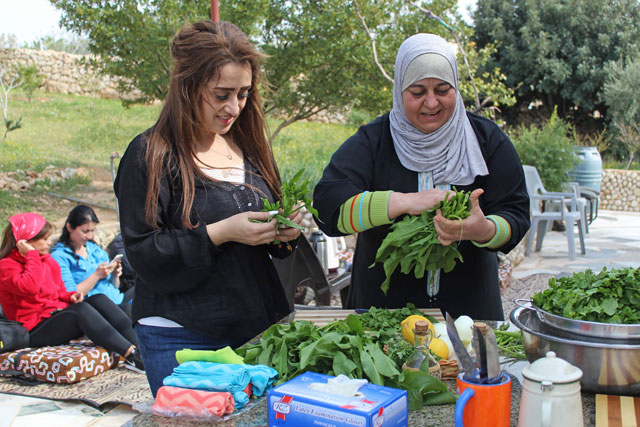 A woman from the village of Eiraa, west of Salt, teaches an Amman resident about the wild plants found in the area  (Photo courtesy of Zikra)