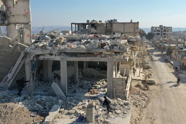 An aerial view shows people trying to recover items from the rubble of a collapsed building in the Syrian rebel-held town of Jindayris on Wednesday (AFP photo)