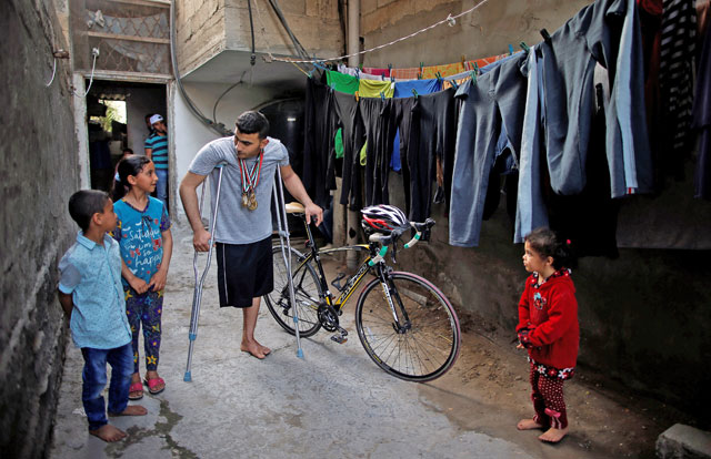 Palestinian cyclist Alaa Al Daly, 21, who lost his leg by a bullet fired by Israeli troops, talks with his sister while holding his bicycle at his house in Rafah, southern Gaza Strip, on Wednesday (Reuters photo)