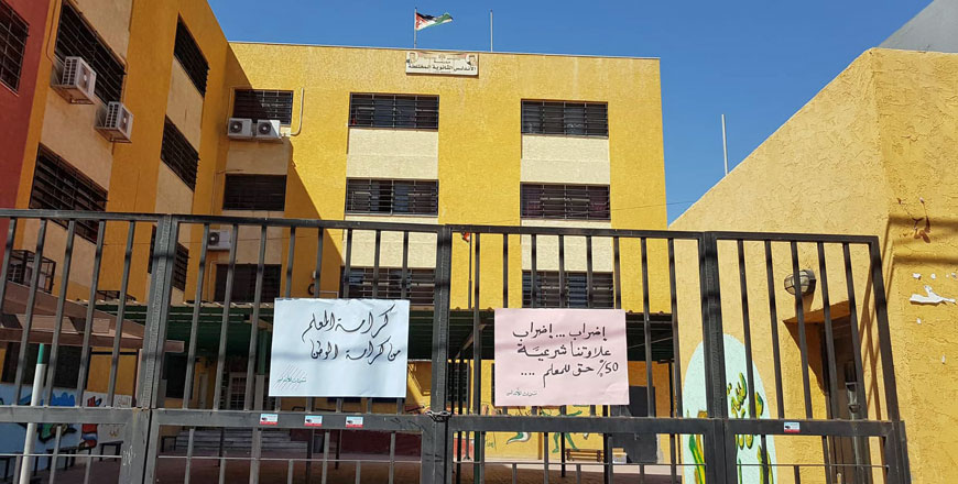   Placards reading ‘Teachers' dignity is Jordan’s dignity’ and ‘Strike... 50% is teachers’ legitimate right’ are hanged on the gates of a deserted public school in this recent photo during an open-ended strike by teachers (Photo by Amjad Ghsoun)