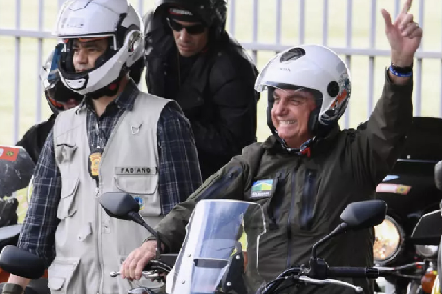 Brazil's President Jair Bolsonaro waves to supporters as he rides a motorcycle leading a caravan of more than 1000 bikers on Sunday (AFP photo)