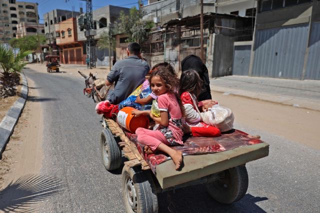 Members of a Palestinian family atop a carriage pulled by a donkey in Beit Lahya in the northern Gaza Strip, flee Israeli air and artillery strikes to a safer location, on Friday (AFP photo)