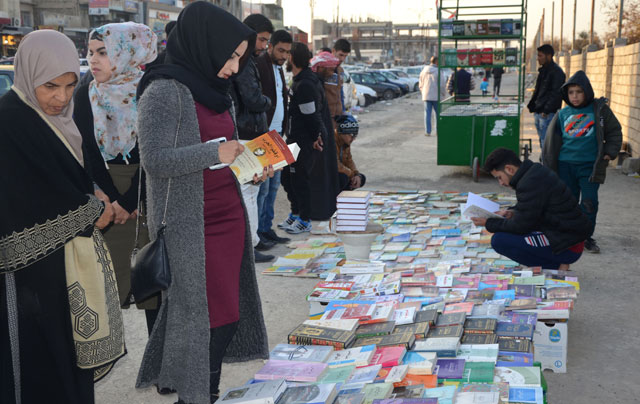 Iraqis buy and sell books on a pavement in the former embattled city of Mosul on January 12, six months after Iraqi forces retook the northern city from Daesh militants (AFP photo)