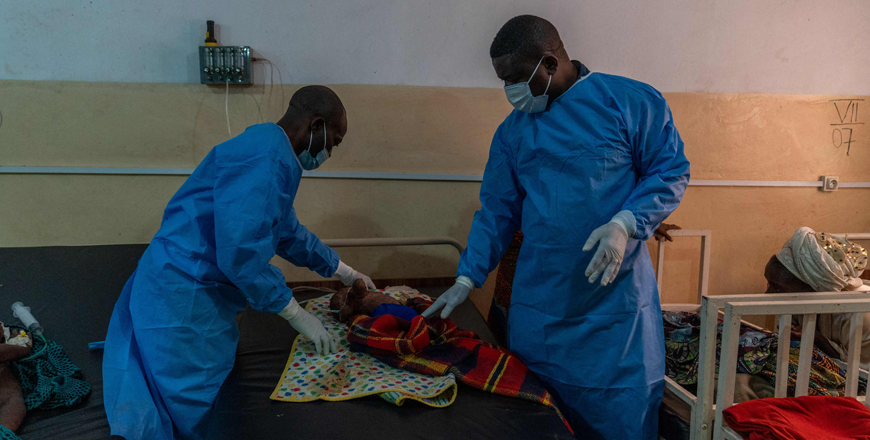 Dr. Robert Musole, medical director of the Kavumu hospital (R) consults an infant suffering from a severe form of mpox at the Kavumu hospital, 30 km north of Bukavu in eastern Democratic Republic of Congo, August 24 (AFP photo)