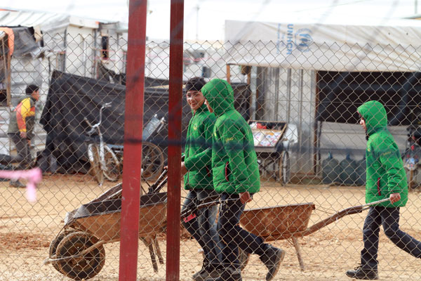 In this photo taken in January 19, at Zaatari Refugee Camp, children are seen pushing  wheelbarrows (Photo by Hassan Tamimi)