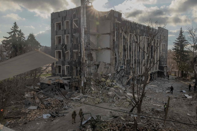 Ukrainian military members and others check a heavily damaged building at the site of a missile attack in Izyum, Kharkiv region, on February 4, 2025 (AFP photo)