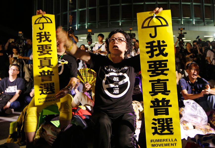 A pro-democracy protester holds placards that read: ‘I want genuine universal suffrage’, during a rally outside the legislative council in Hong Kong on Wednesday (AP photo)