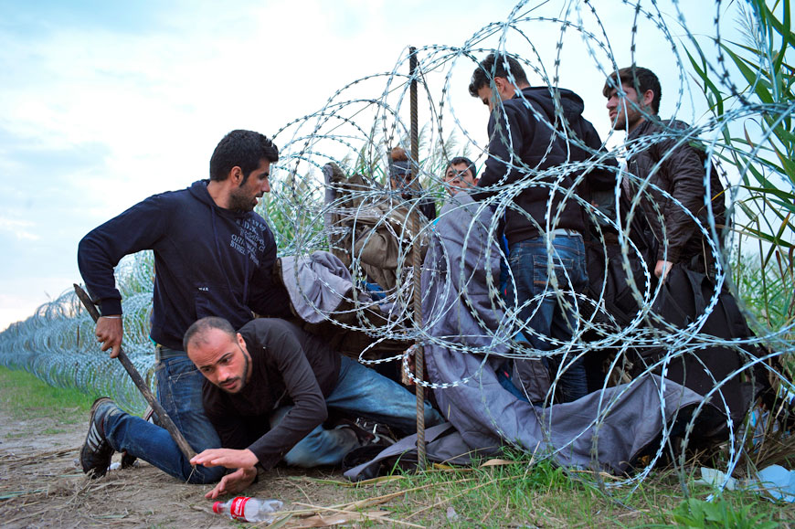 Syrian refugees cross into Hungary underneath the border fence on the Hungarian-Serbian border near Roszke, Hungary, on Tuesday (AP photo)