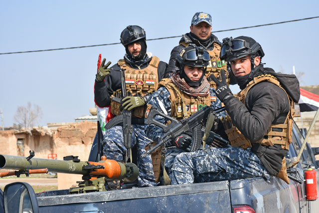 Members of Iraqi security forces pose for a photo in Hawija district, which was cleared from all Daesh terrorists almost 5 months ago, of Kirkuk, Iraq, on Wednesday. Iraqi security forces provide road security for 580 families of Hawija, who live in camps in Kirkuk (Anadolu Agency photo)