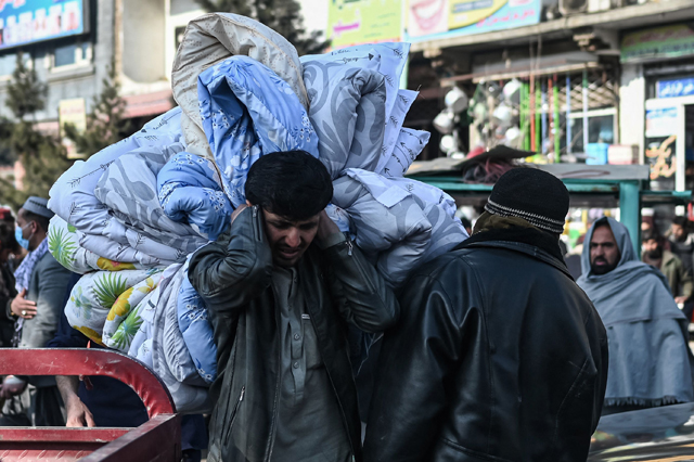 A man carrying duvets walks along a street in Kabul, on January 29 (AFP photo)