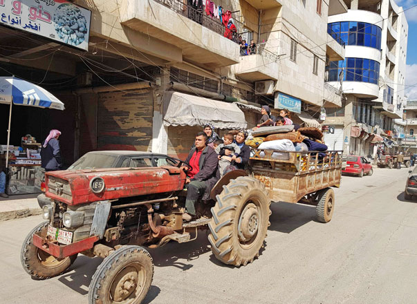 Civilians drive in the city of Afrin, which is nearly surrounded by Turkish-led forces, in search of a safe place to take shelter on Wednesday (AFP photo)