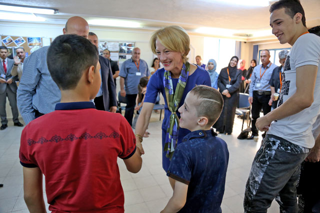  In this photo taken Sunday, US Ambassador to Jordan Alice G. Wells shakes hands with Syrian refugee Hamzeh Jouriyeh, 12, ahead of his departure to the United States (AP photo by Raad Adayleh)