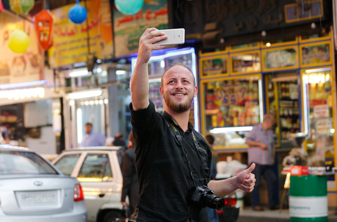 Syrian soldier Mohammad Damour takes a selfie at a street market in Damascus after he was discharged from the Syrian army on June 4, having served eight instead of the two mandatory years (AFP photo)