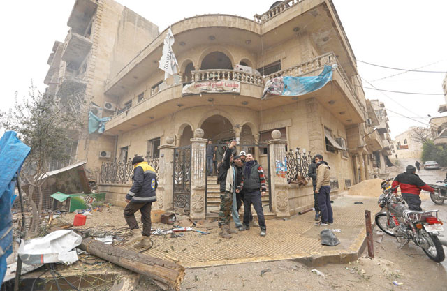 Syrian friends pose for a selfie in front of a hospital in Maaret Al Numan after they found their friend alive, who was working at the hospital when an air strike struck in Syria's rebel-held Idlib province on Wednesday (AFP photo)
