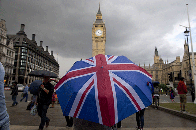 In this file photo taken on June 25, 2016 A pedestrian shelters from the rain beneath a Union flag themed umbrella as they walk near the Big Ben clock face and the Elizabeth Tower at the Houses of Parliament in central London on June 25, 2016, following the pro-Brexit result of the UK's EU referendum vote (AFP photo)