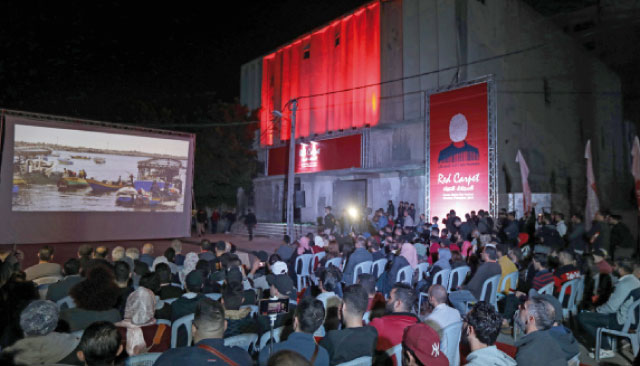 Palestinians watch a film during the opening ceremony of the Red Carpet Human Rights Film Festival in Gaza-Karama Palestine, in front of the abandoned Amer Cinema building in Gaza City, on Wednesday (AFP photo)