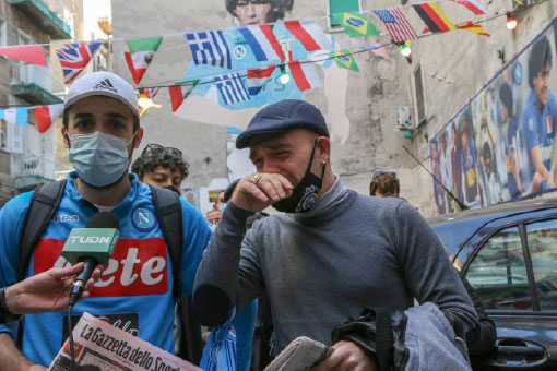 People react as they gather to mourn Argentinian football legend Diego Maradona on Thursday in the Spanish quarters of Naples, a day after the death of Maradona (AFP photo)