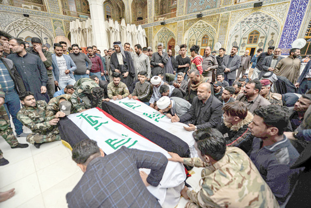 Mourners pray over coffins draped with the Iraqi national flag inside the Imam Ali Shrine in the central Iraqi holy shrine city of Najaf on Friday (AFP photo)