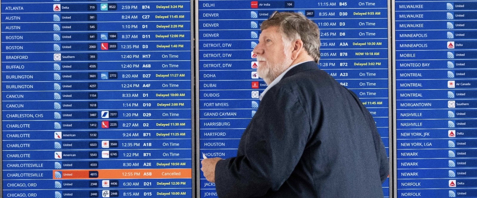 A passenger walks past a flight information board showing multiple delays and some cancellations in flight departures from Dulles International Airport on July 19, 2024 in Dulles, Virginia (AFP photo)
