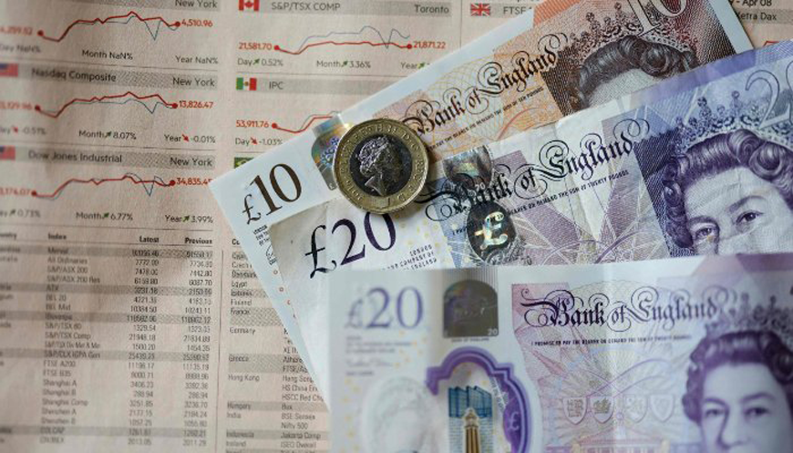 Sterling pound banknotes and coins displayed on a table in London, UK (AFP file photo)