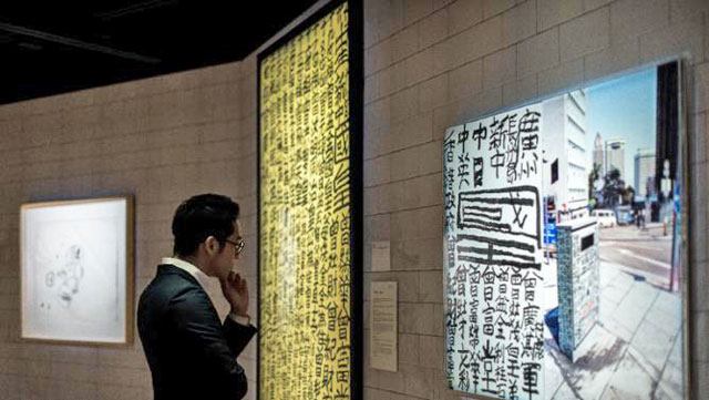 A man looks at an artwork by Tsang Tsou Choi during a preview of an exhibition titled ‘They would be kings’ held by the Sotheby's auction house in Hong Kong on March 18 (AFP photo)