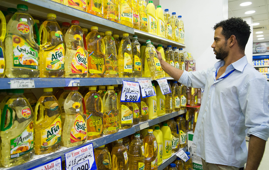 A worker arranges oil containers at a supermarket in Amman on Monday (Photo by Amjad Ghsoun)