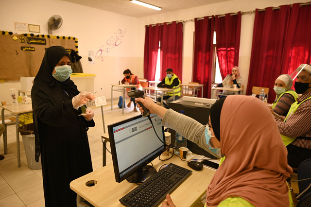 A woman registers to vote at a polling station in Amman on Tuesday (Photo by Amjad Ghsoun)