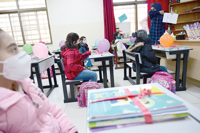 A teacher is seen teaching students hygiene practices on the first day of the 2020/2021 second semester in a classroom in a school in Amman on Sunday (Photo by Amjad Ghsoun)