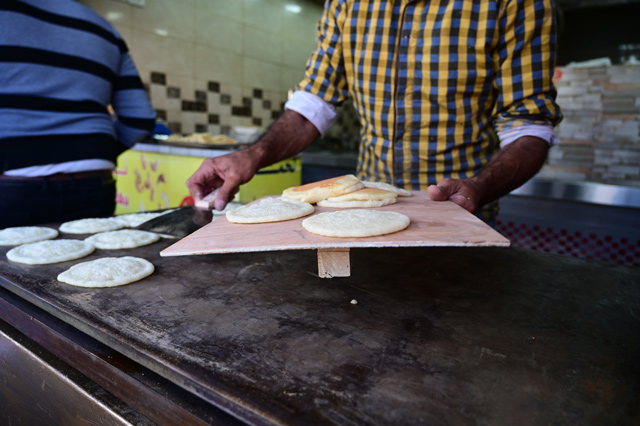 A vendor prepares qatayef, pancakes stuffed with cheese, nuts, or cream and then baked or fried before they are dipped in condensed sugar syrup, usually served in Ramadan, in downtown Amman on Wednesday (Photo by Amjad Ghsoun)