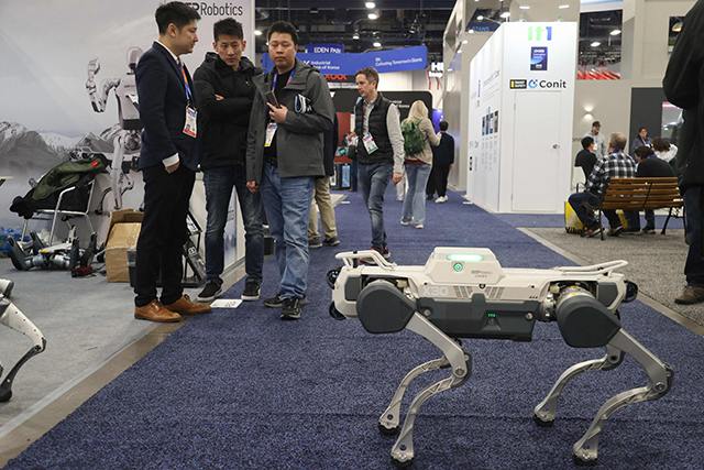 Attendees watch as a robot walks around at the DEEP Robotics booth during the Consumer Electronics Show (CES) in Las Vegas, Nevada, on Thursday (AFP photo)