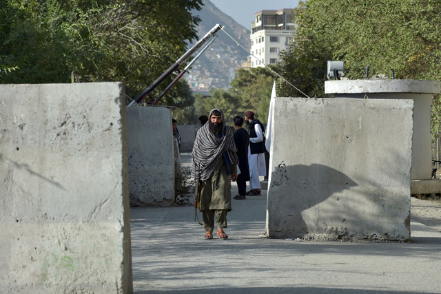 A Taliban fighter walks through a gate after Taliban announced the reopening for passport applications, at the passport office in Kabul, on Wednesday (AFP photo)