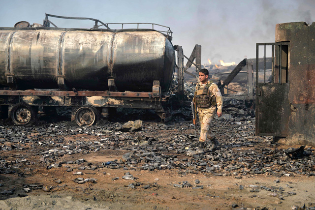A security forces personnel walks amidst wreckage of gas tankers after a fire accident at Islam Qala on the outskirts of Herat, in the border between Afghanistan and Iran, on Sunday (AFP photo)